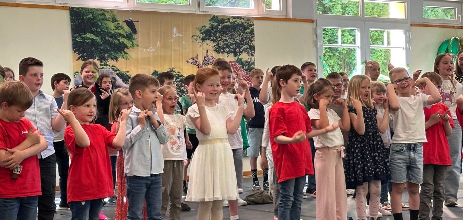 Das Bild zeigt Schulkinder bei einem Gesangsvortrag