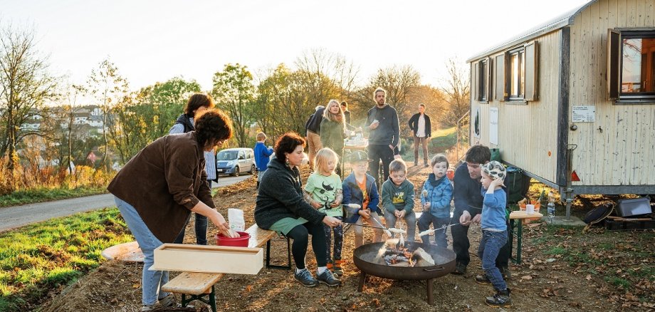 Kinder und Erwachsene backen Stockbrot am Feuer nach der Aktion Heidenspaß 2024