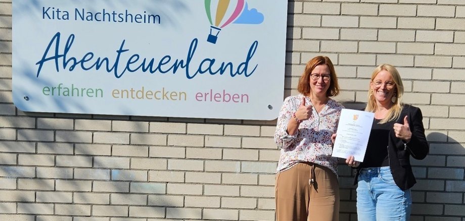 Foto (v.l.n.r.): Die neue Kollegin Melanie Jordan und Kathrin Gasper, Leiterin der Kita Abenteuerland in Nachtsheim, nach Unterzeichnung des Arbeitsvertrages vor ihrer gemeinsamen Wirkungsstätte.