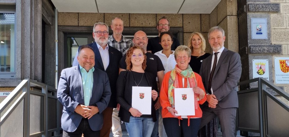 Das Foto zeigt: Bürgermeister Alfred Schomisch mit der neuen Schiedsfrau Nelli Fuchs, der scheidenden Schiedsfrau Gisela Klier, Dr. Marcel Heinemann, Direktor des Amtsgerichts Mayen (untere Reihe, v.l.n.r.); Hans-Jürgen Gross vom BDS, Markus Fuchs (Ehemann von Nelli Fuchs), Vivian Hannor, Sachbearbeiterin VG Vordereifel und Carmen Schäfer, Sachgebietsleiterin VG Vordereifel (mittlere Reihe, v.l.n.r.) sowie Thomas Hammes, Schiedsmann für Schiedsmannsbezirk III und Ortsbürgermeister Frank Pohl aus Kirchwald (obere Reihe, v.l.n.r.) nach den offiziellen Urkundenübergaben