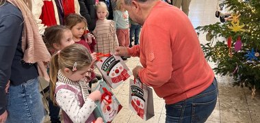 Das Bild zeigt Bürgermeister Alfred Schomisch beim Verteilen der Geschenktüten an die Kinder Das Bild zeigt Bürgermeister Alfred Schomisch beim Verteilen der Geschenktüten an die Kinder