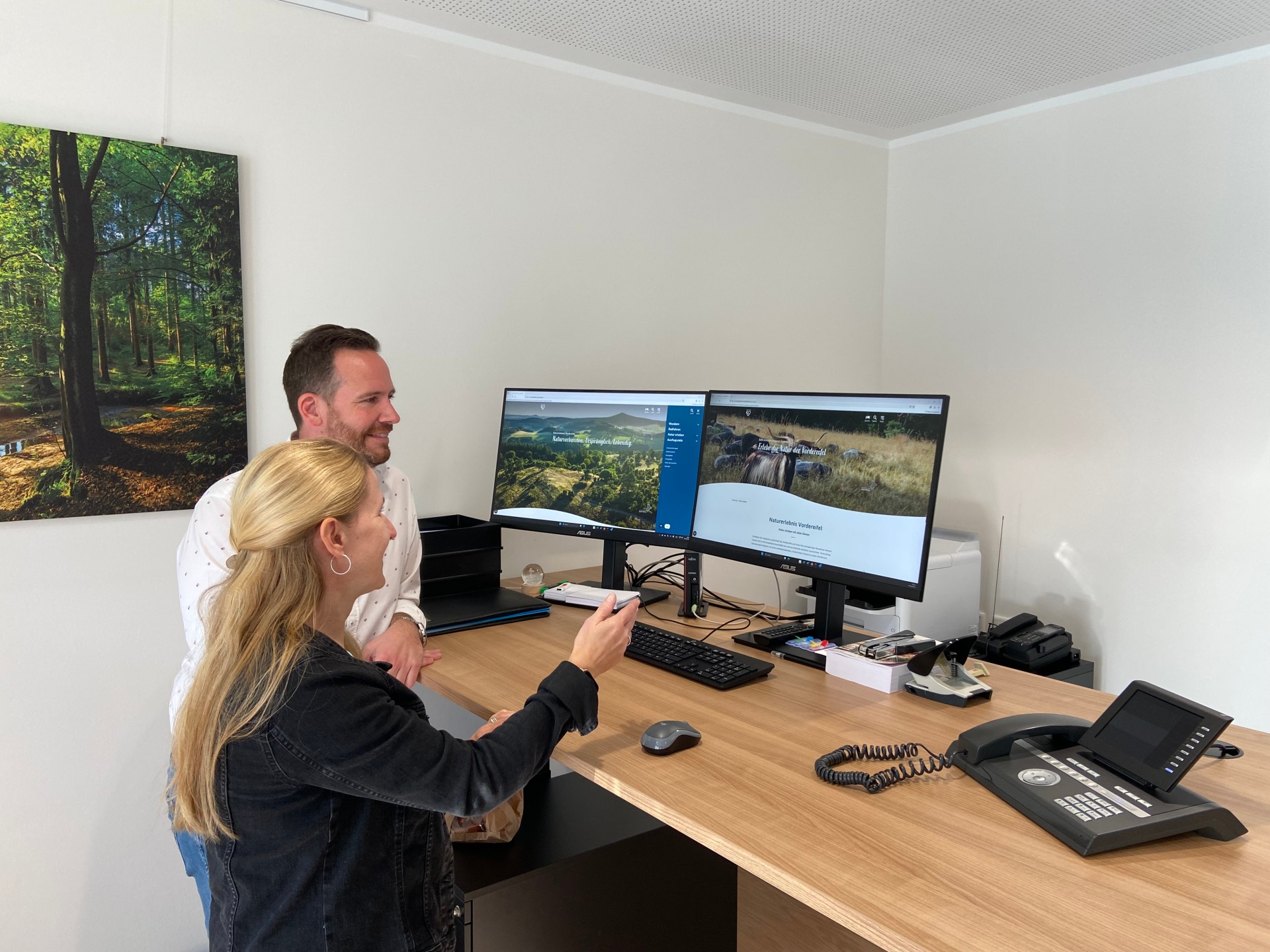 Bürgermeister Timo Kanzinger und Touristikerin Svenja Schulze-Entrup sehen sich die angepasste erneuerte Internetseite www.naturerebnis-vordereifel.de an