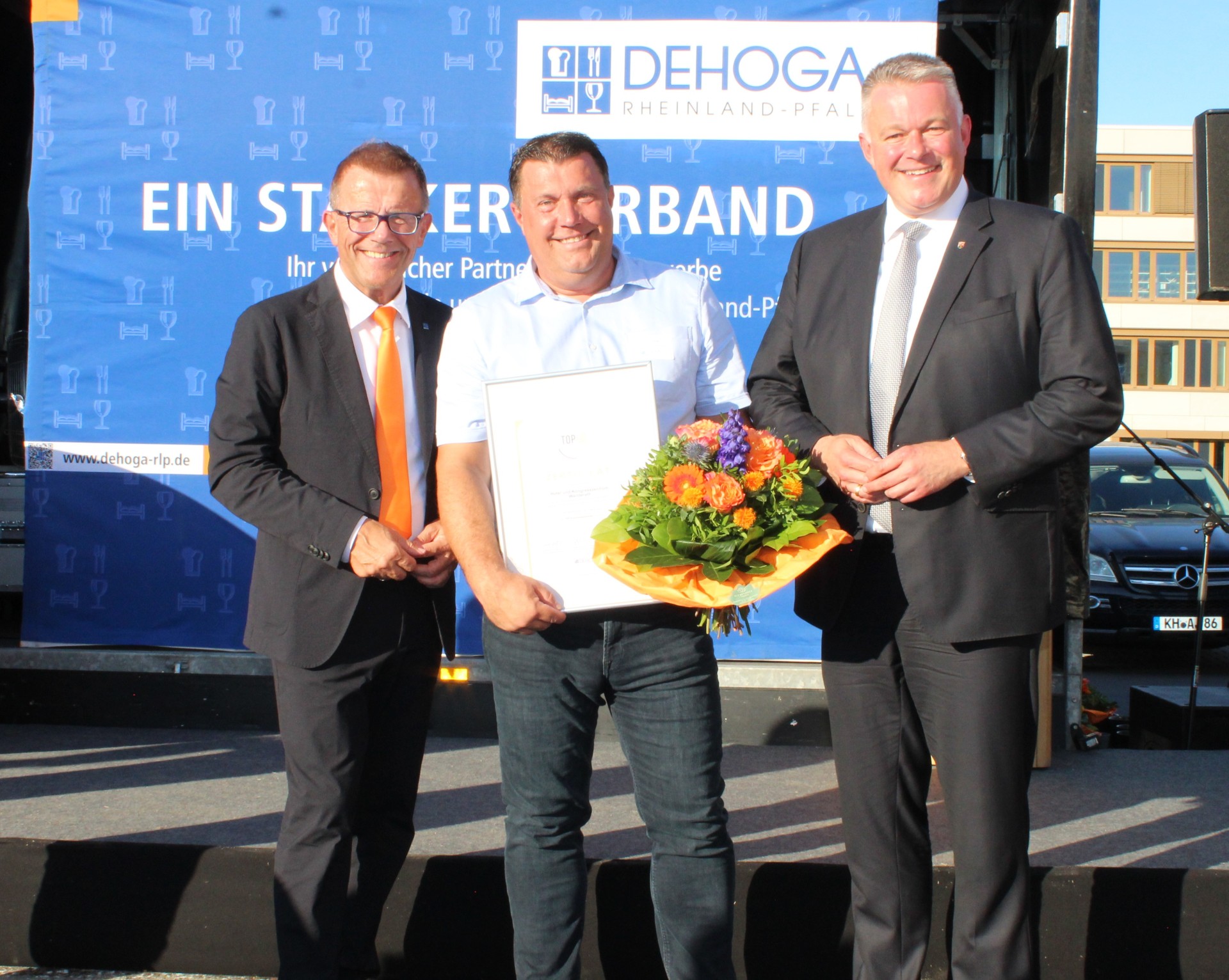 Das Bild zeigt Gereon Haumann (Präsident DEHOGA RLP), Thomas Sztrajt (Leiter Hotel und Kongresszentrum Wanderath) und Gordon Schnieder (Ministerpräsident RLP) bei der feierlichen Auszeichnung.
