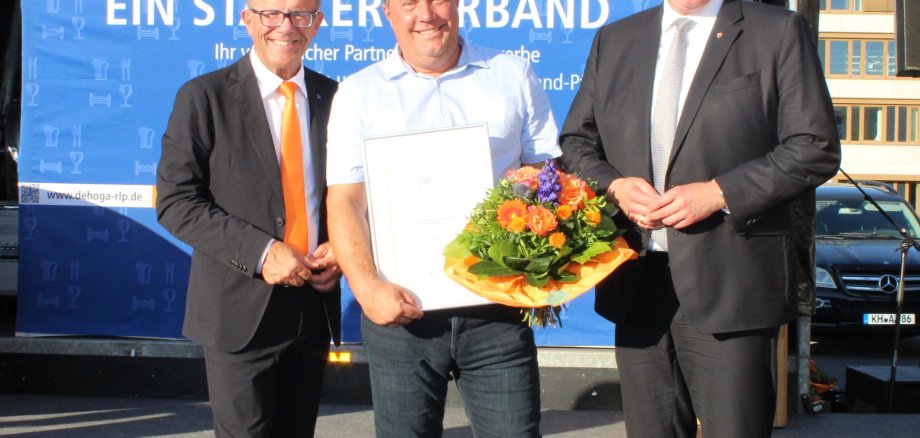 Das Bild zeigt Gereon Haumann (Präsident DEHOGA RLP), Thomas Sztrajt (Leiter Hotel und Kongresszentrum Wanderath) und Gordon Schnieder (Ministerpräsident RLP) bei der feierlichen Auszeichnung. Das Bild zeigt Gereon Haumann (Präsident DEHOGA RLP), Thomas Sztrajt (Leiter Hotel und Kongresszentrum Wanderath) und Gordon Schnieder (Ministerpräsident RLP) bei der feierlichen Auszeichnung.