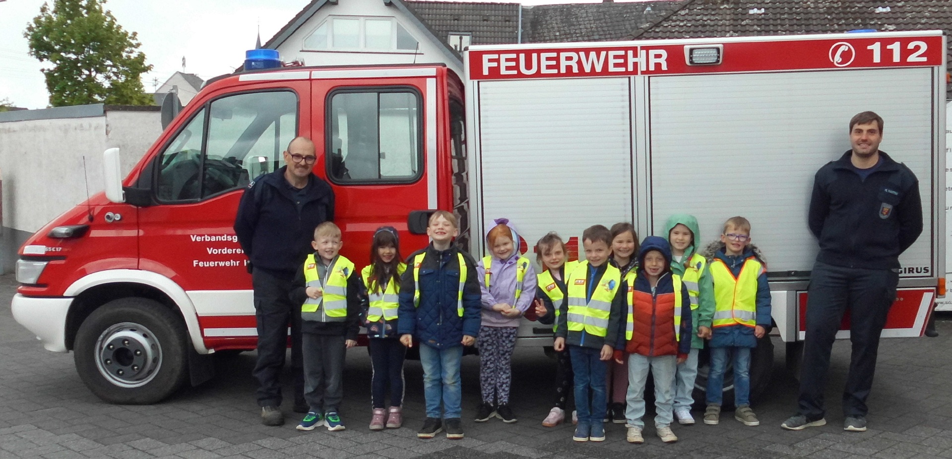 Das Bild zeigt die Maxi Kinder vor einem Feuewehrauto