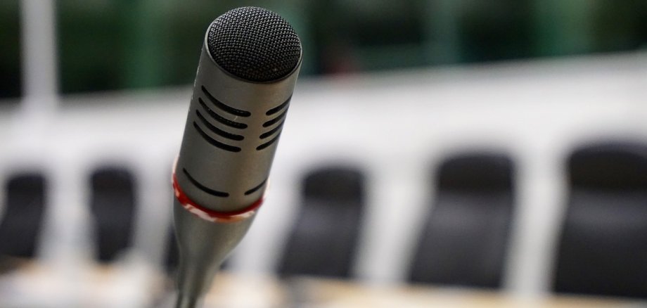 Abbildung eines Mikrofons an einem Konferenztisch