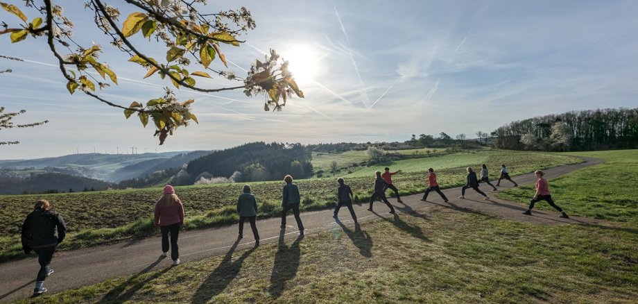 Das Bild zeigt die Teilnehmenden bei einer Yogaübung Das Bild zeigt die Teilnehmenden bei einer Yogaübung